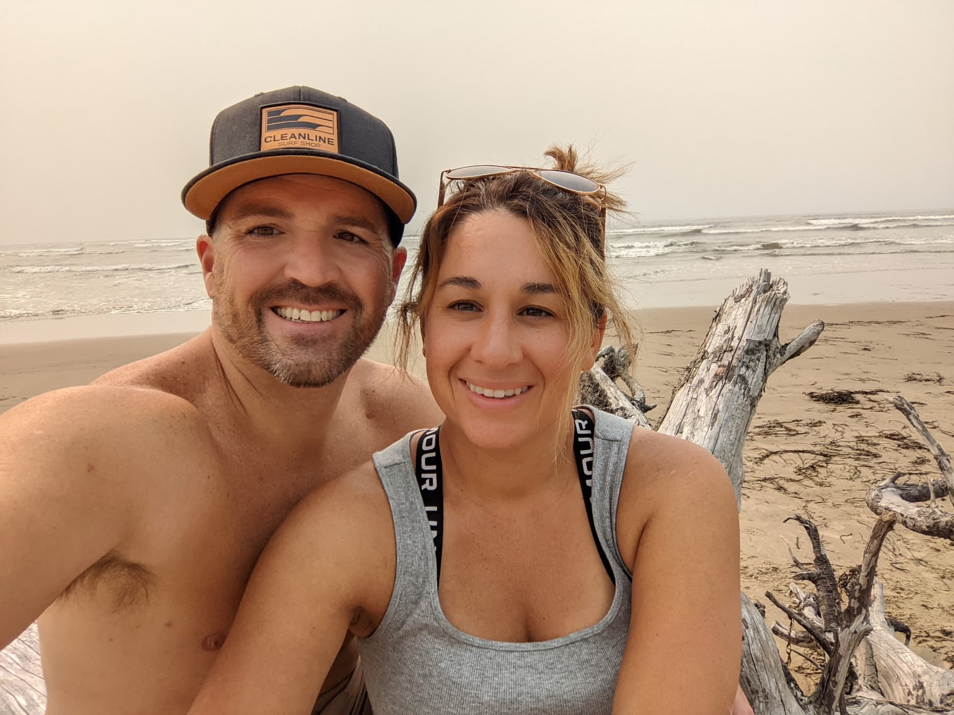 Leah and her husband smiling together on a beach