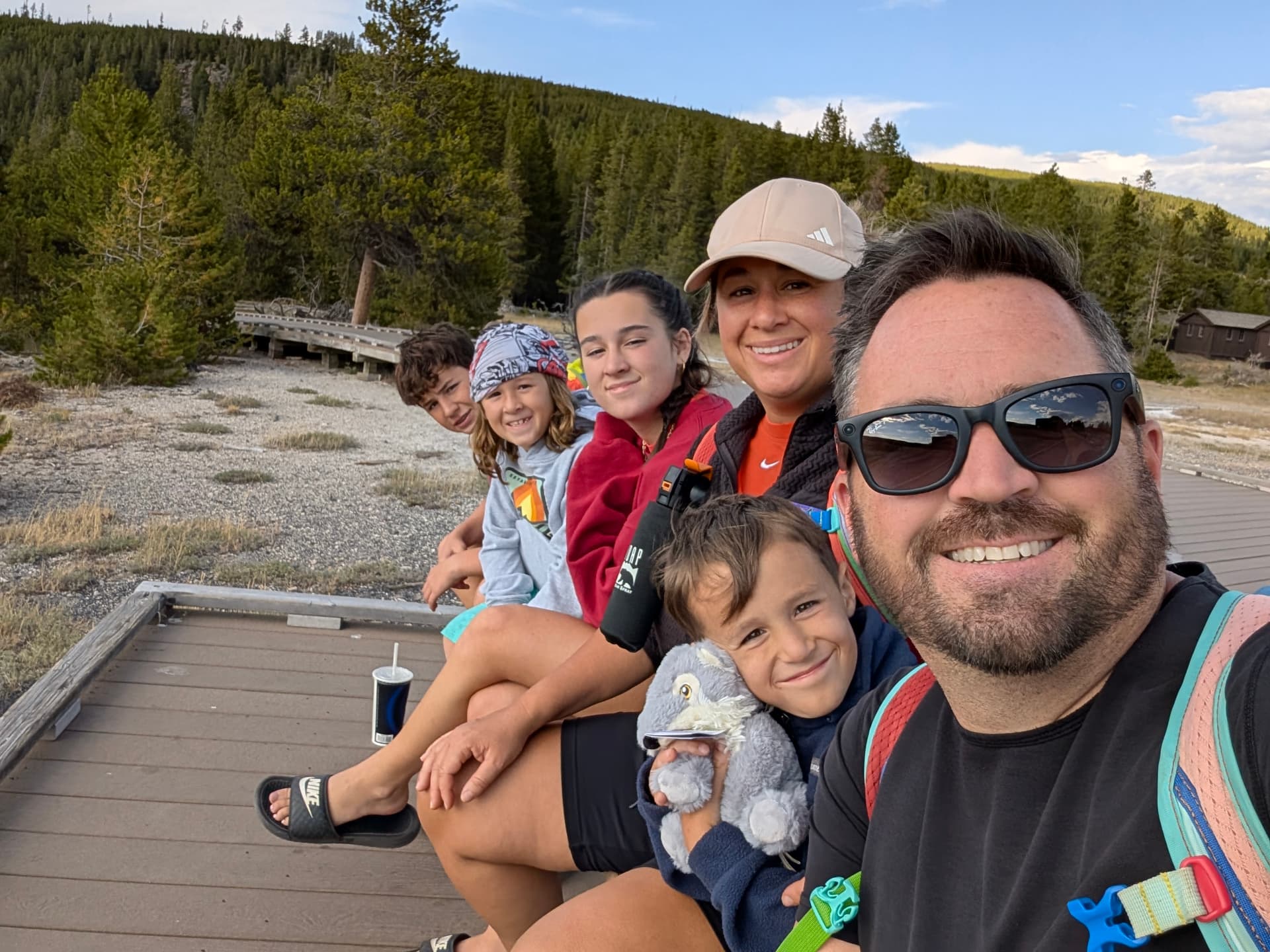 Leah's family walking a Yellowstone boardwalk past steaming hot springs